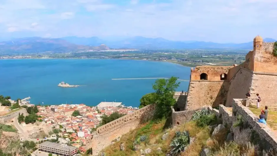 Θέα από το Παλαμήδι στο Ναύπλιο με επισκέπτες να κοιτάζουν το Μπούρτζι και τον Αργολικό κόλπο για 3ήμερο στην Αργολίδα